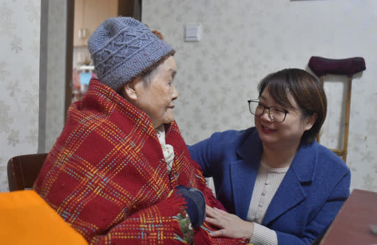 陈虹（右）上门看望一位百岁老人，和老人拉家常，了解老人生活所需。 记者 崔景印 摄.jpg