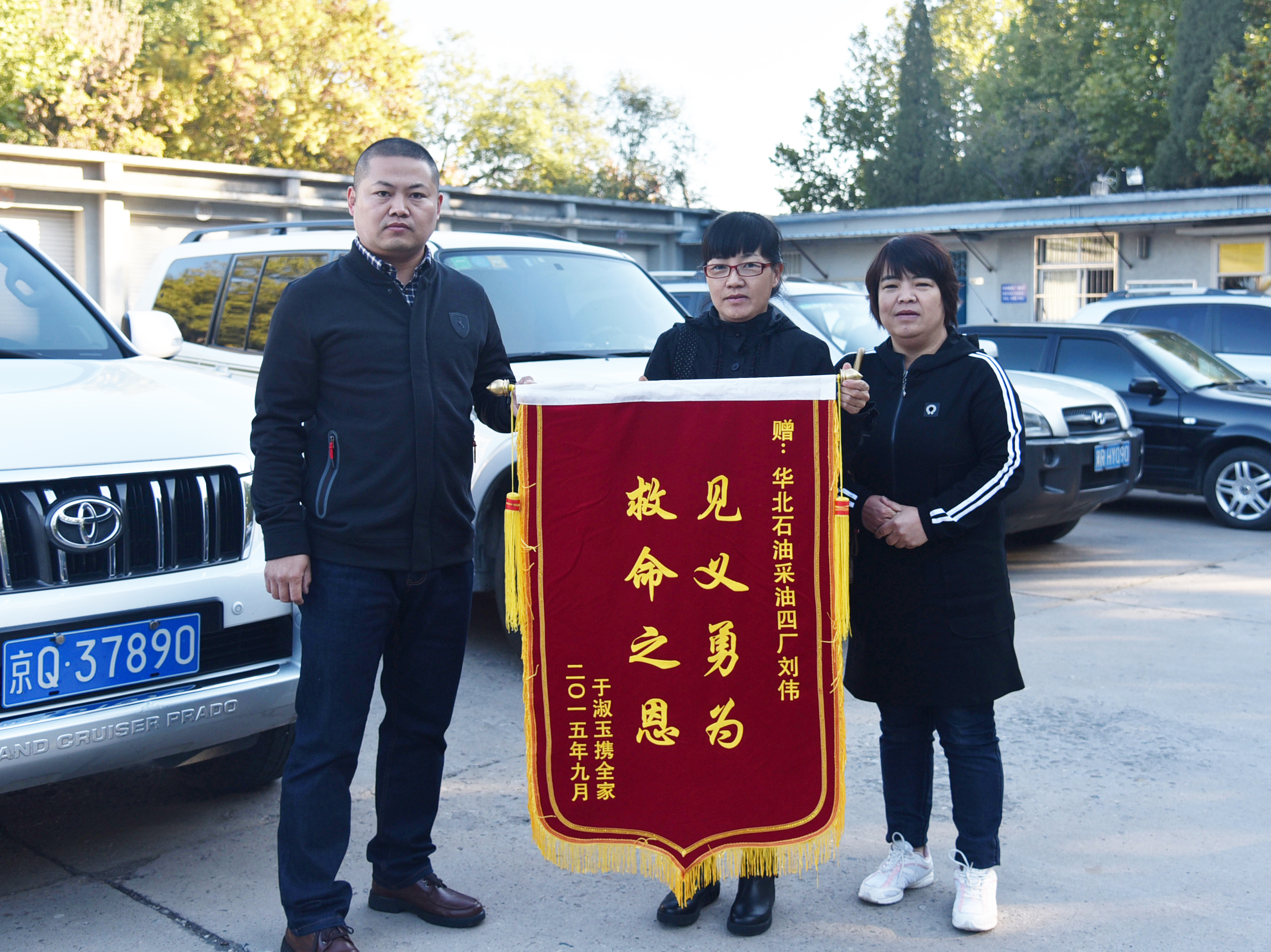 被救老人的家人送来锦旗表示对刘伟（左）的谢意。.JPG