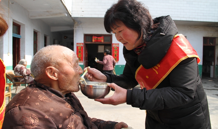 门金梅为孤寡老人喂饭。图片来源：河南省文明办.jpg