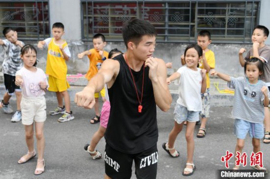 图为大学生志愿者在组织孩子们参加体育健身活动。　廖光福 摄